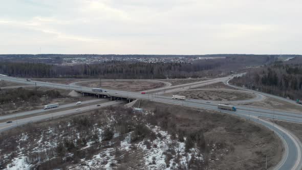 A Car Interchange with an Overpass on a Cloudy Spring Evening in the Woods