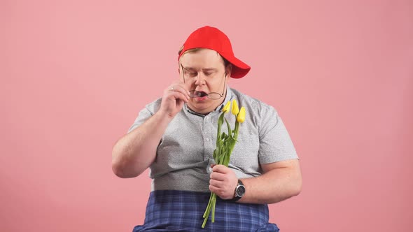 Hesitating Plump Man Waiting for Girlfriend with Flowers on Pink Background