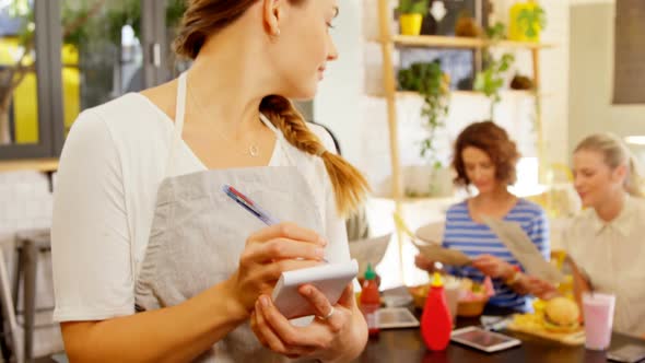 Beautiful waitress writing order in notepad 4k