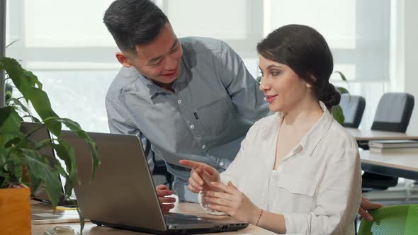 Asian Businessman Discussing Startup Ideas with His Female Colleague