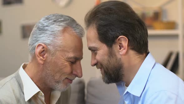 Senior Man and Mature Son Touching Foreheads, Family Unity, Togetherness Concept