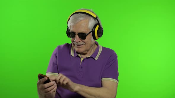 Elderly Stylish Caucasian Grandfather Man Using Social Media App on Smartphone