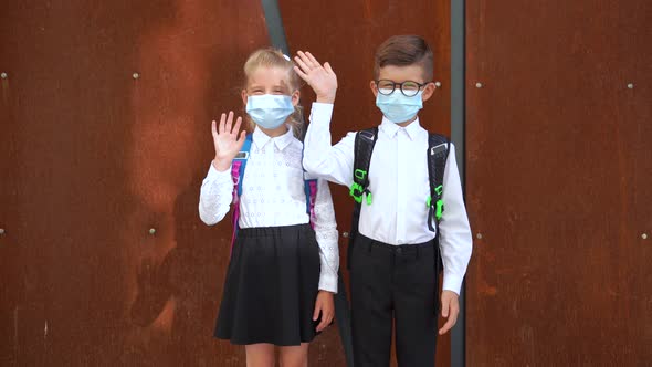 Schoolchildren in Masks with Backpacks Saying Hello During COVID 19