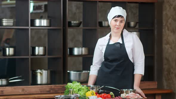Smiling Female Cook Worker in Apron Posing at Restaurant Kitchen Interior