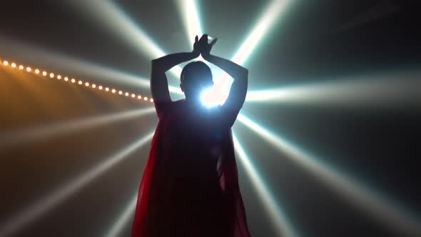 Silhouette a Young Girl Dancer in a Red Sari. Indian Folk Dance. Shot in a Dark Studio with Smoke