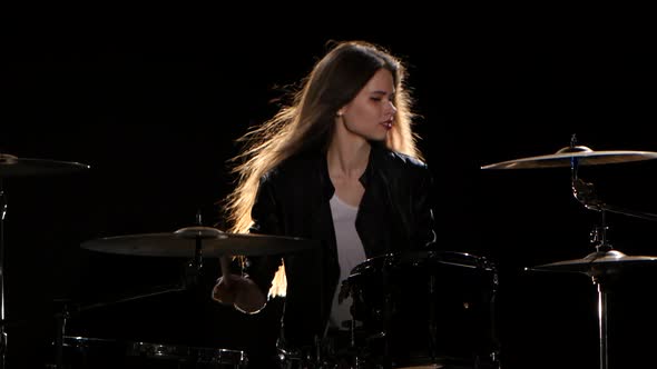 Drummer Girl Starts Playing Energetic Music, She Smiles. Black Background