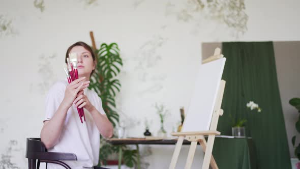 A Female Artist Checks Brushes for Drawing