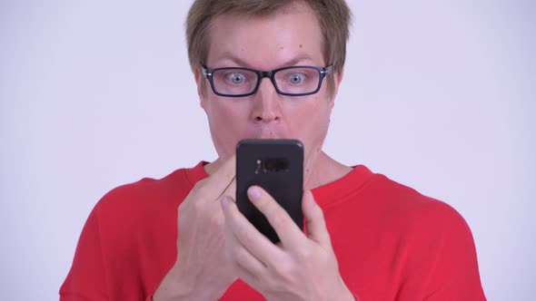 Face of Young Man Using Phone and Looking Shocked