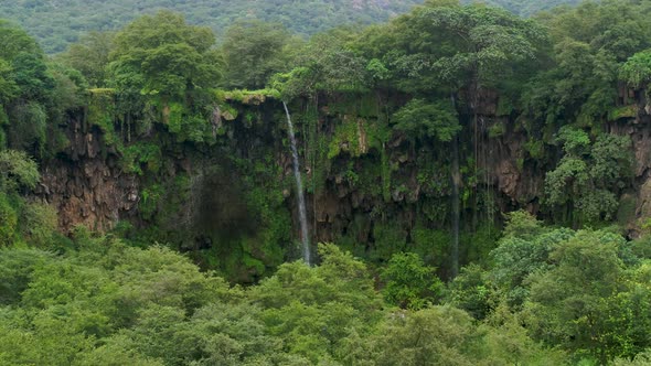 Natural scenery rain forest and waterfalls on a rocky cliff