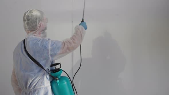 Worker of Urban Service is Disinfecting Building Inside Spraying Sanitizer