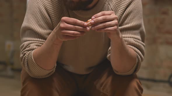 Depressed Man Crumpling Name Tag in Hands at Therapy Session