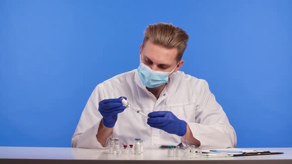 Male Doctor Work in Laboratory Exploring a Vaccine and Making Log Entries