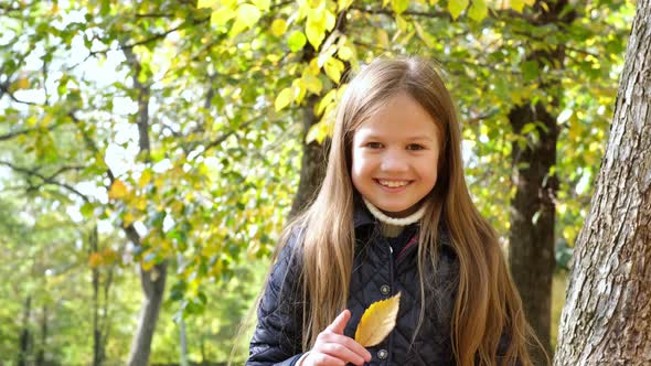 Autumn Portrait of Cute Little Blond Girl in City Park