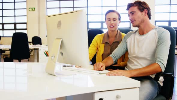 Colleagues looking at computer and discussing with each other