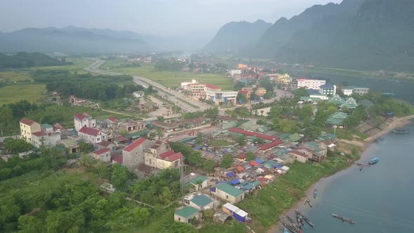 Compact Town Located on Wide Blue River Bank Under Grey Sky