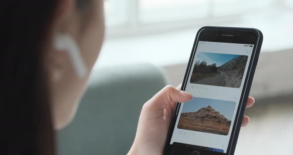 Young Woman Using Smartphone Scrolling Through Social Network Feed Doing Swiping