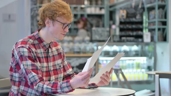 Happy Redhead Man Celebrating Success Reading Documents