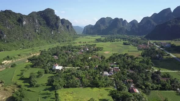 Aerial View Village Houses Among Trees in Green Valley