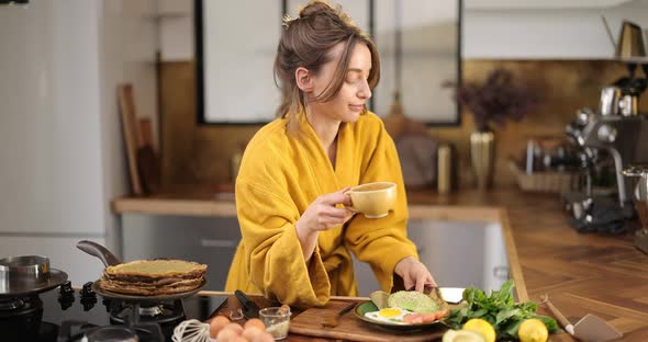 Woman Having a Breakfast on the Kitchen at Home