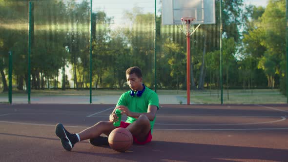 Basketball Player Drinking Water on Outdoor Court