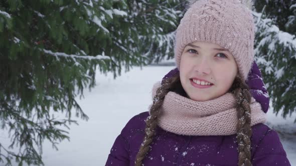 Portrait of a Happy Teenage Girl in a Snowy Park