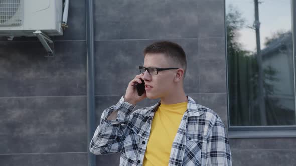 Young Man is Chatting with Friend on Phone