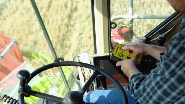 Male Hands Farmer Driver on Steering Wheel Combine Harvest on Agricultural Field