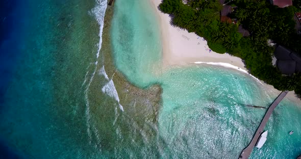 Daytime fly over clean view of a white paradise beach and blue sea background in high resolution 4K