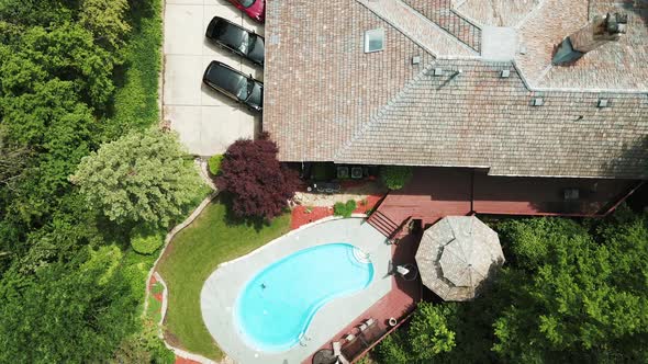 cinematic aerial view of a luxury residential house with personal swimming pool with 3 luxury cars 4