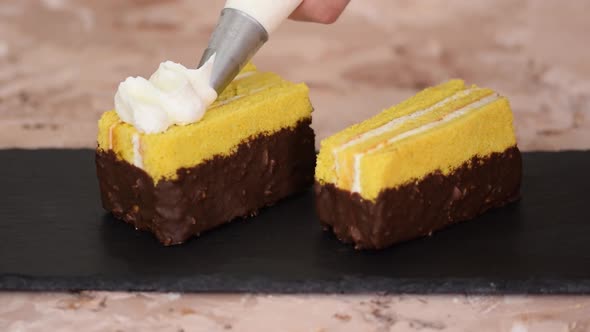 Female Hands Decorate a Sponge Cakes with Cream From a Pastry Bag with a Nozzle