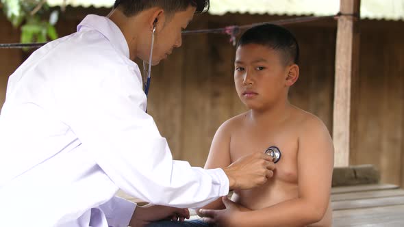 Doctor Examining Rural Boy By Stethoscope