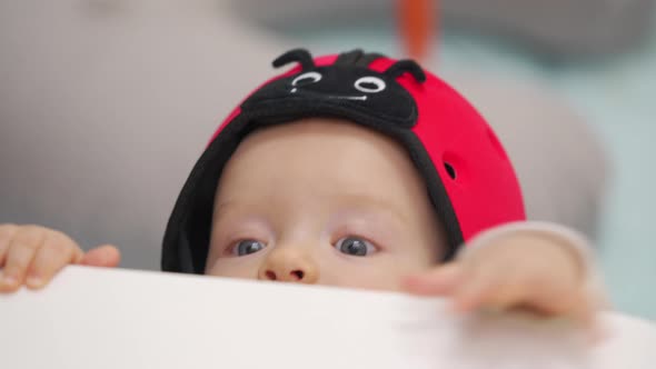 Cute Baby Boy Wearing Soft Safety Helmet Discovering New Things at Home 7 Month Old Infant on the