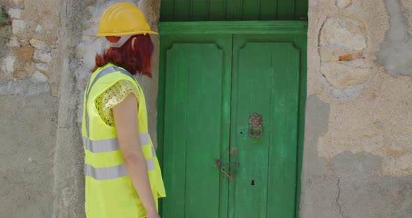 Woman technician leaves a flower at the door for mourning the victims of the earthquake in the city