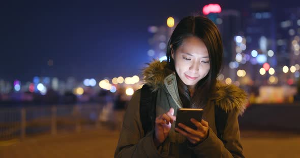 Asian woman use of smart phone in city at night