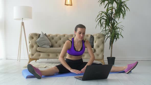 Sporty Fit Woman with Laptop Stretching Muscles