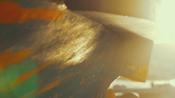 Golden hour light reflected onto fishing boat while fisherman paints