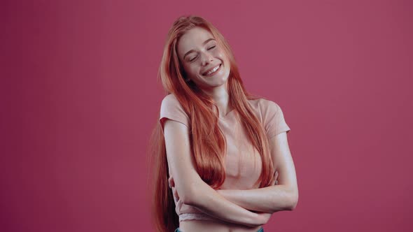 Young Smiling Redhead Modest in Profile Cheerful for 20 Years in a Pink Casual Tshirt Isolated on a