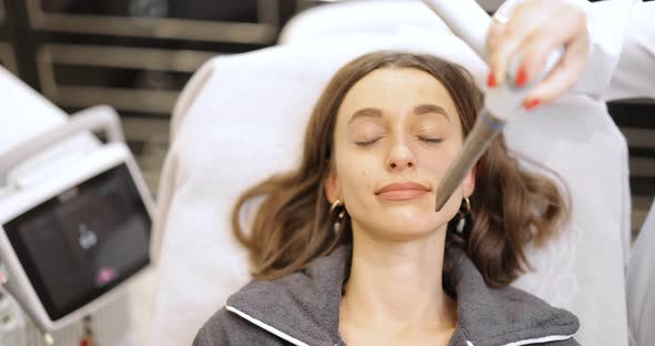 Cosmetologist Doing Laser Facelifting Procedure in Beauty Clinic