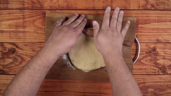 Stretching the dough with the wooden stick.