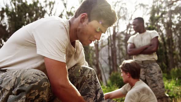 Military soldier tying shoelaces at boot camp 4k