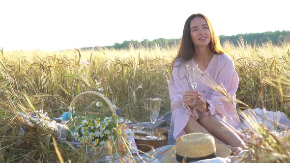 Beautiful Girl in Wheat Field with Ripe Wheat in Hands