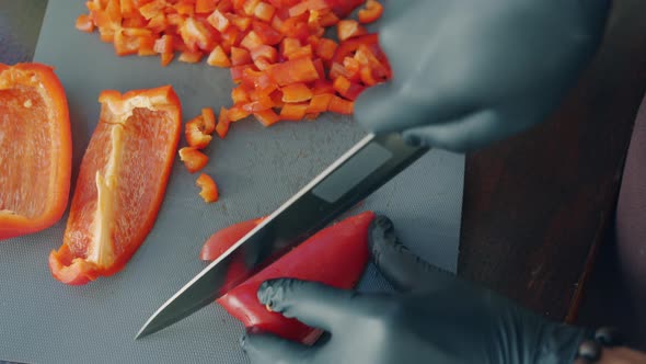 Top View of Cook's Hands in Gloves Chopping Juicy Pepper in Kitchen Making Salad