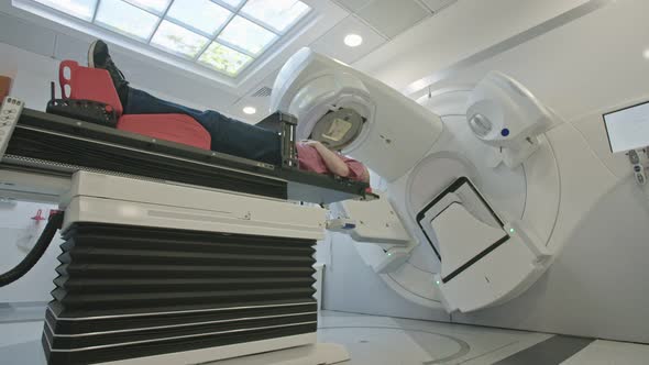 Patient Getting Radiation Therapy Treatment Inside A Modern Radiotherapy Room