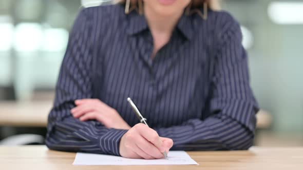 Close Up of Businesswoman Writing on Paper 