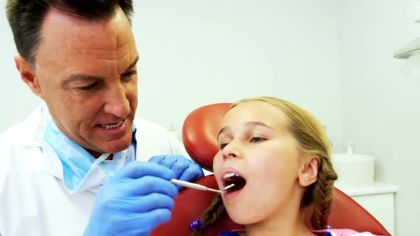 Dentist examining a young patient with a tool
