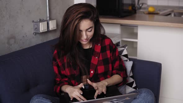 Sexy Girl in Red Flennel Shirt Trying to Type Something on Her Laptop Keyboard with Her Super Long