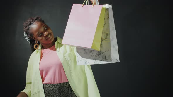 Positive Afro Girl Posing for Camera with Shopping Bags