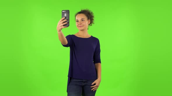 Curly Woman Making Selfie on Mobile Phone Then Looking Photos . Green Screen