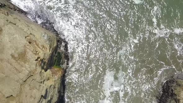 Slow motion from the cliffs to the bird rock in the water Wonderful aerial view flight slowly tilt u