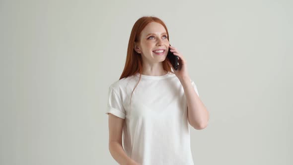 Portrait of Happy Smiling Young Woman Having Pleasant Mobile Conversation Using Smartphone Standing